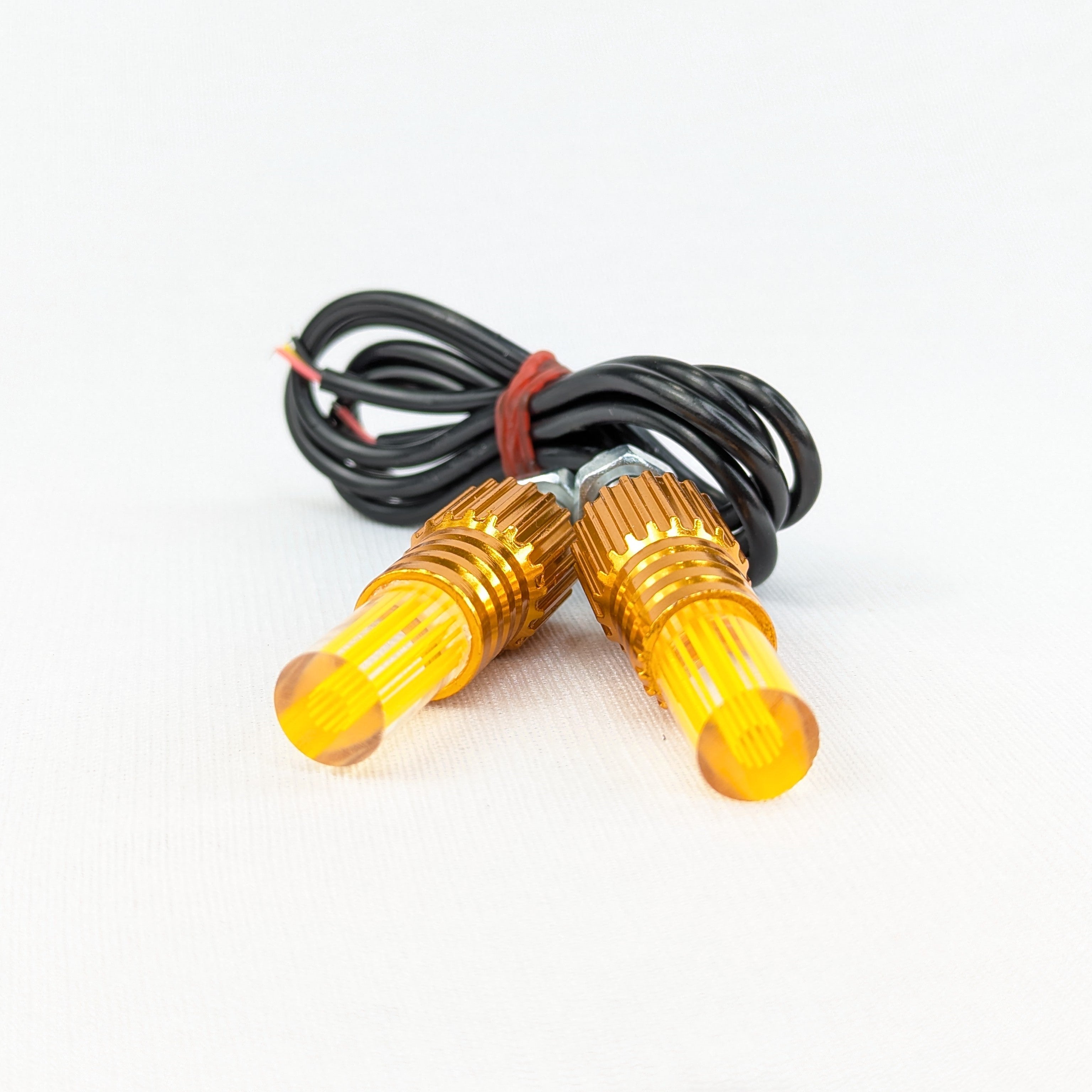 Two yellow indicator lights with wiring on a white background