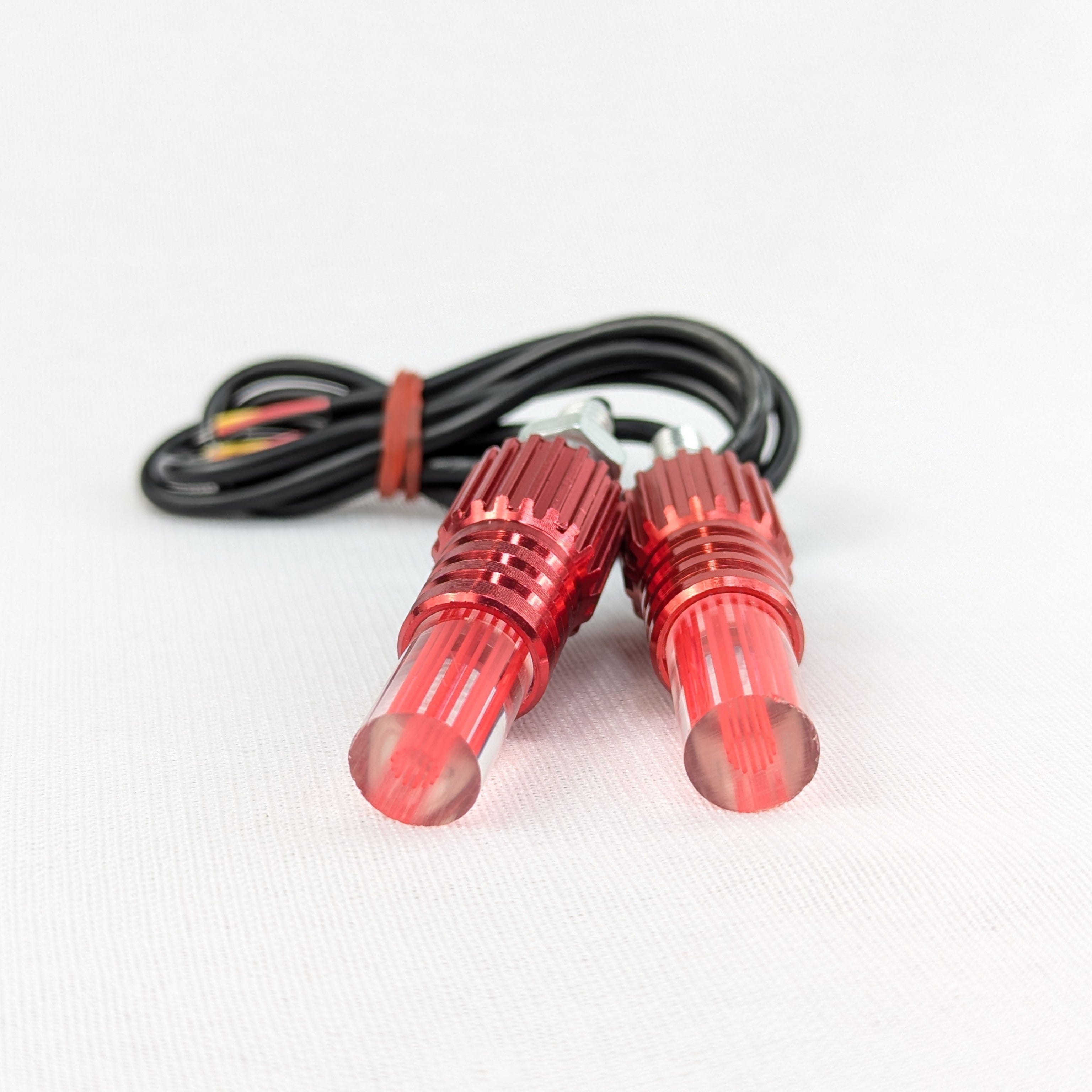 Two red LED lights with a cable on a white background