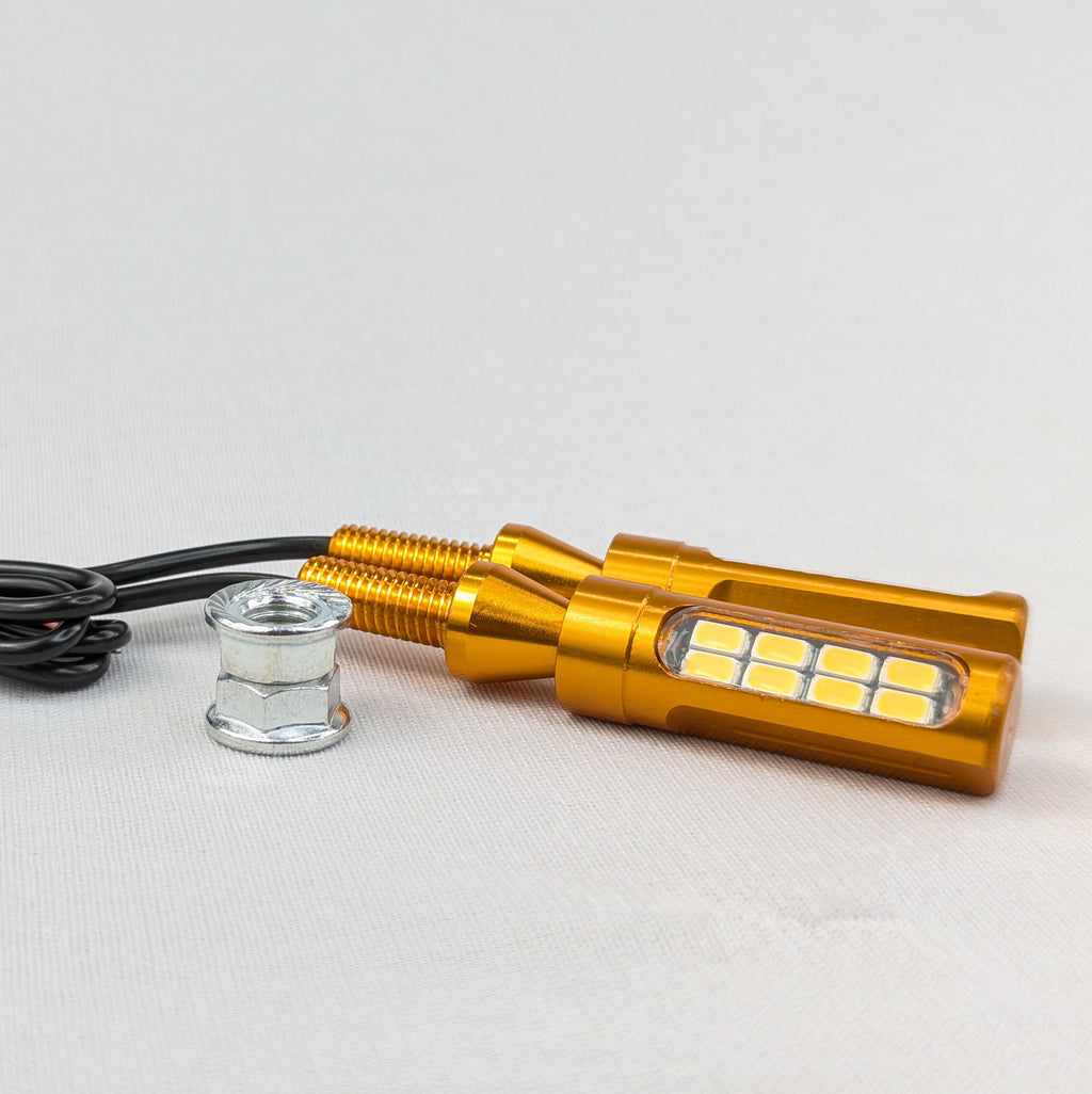 Gold LED light bulb with black wire on a white background