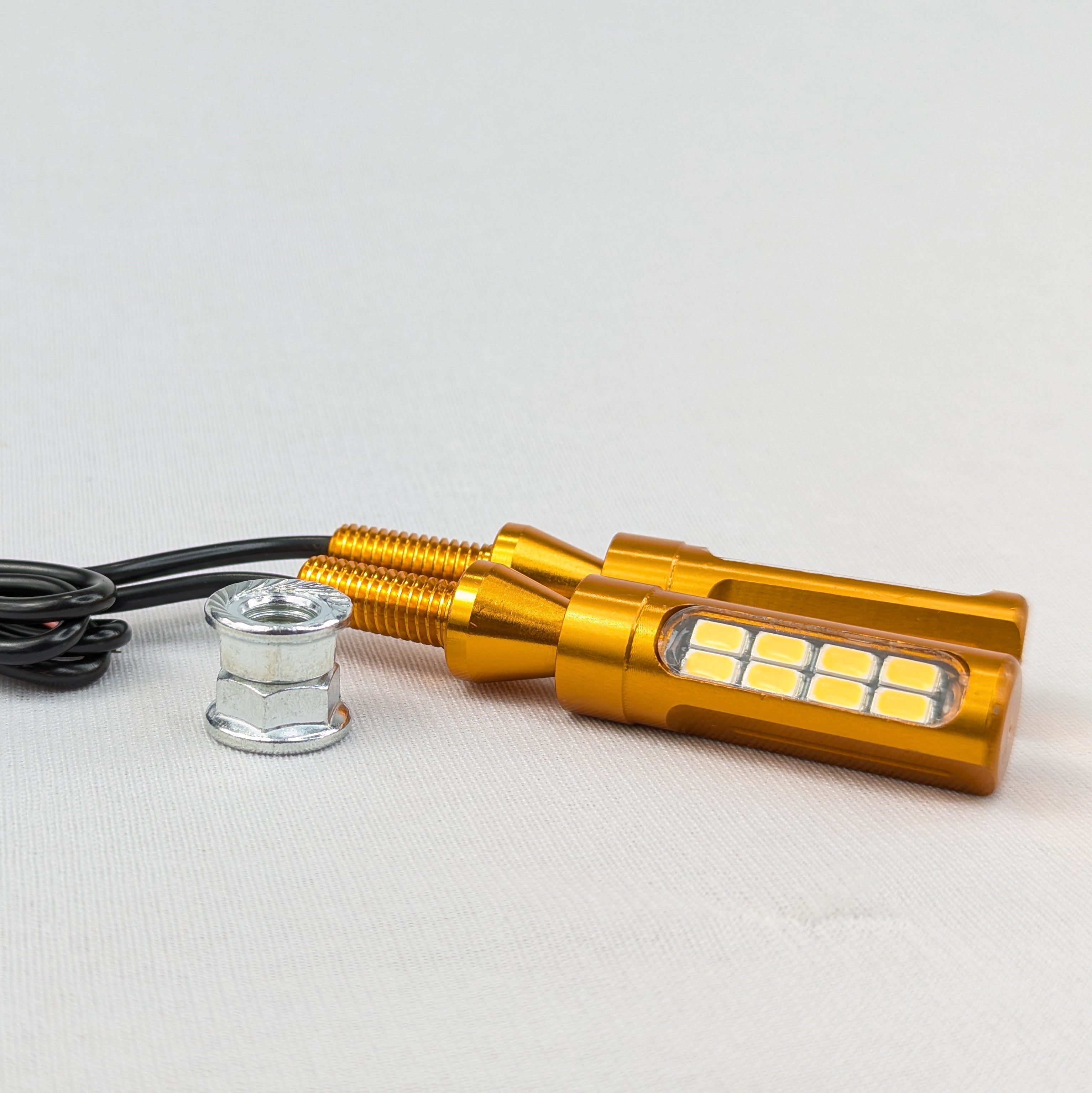 Gold LED light bulb with black wire on a white background