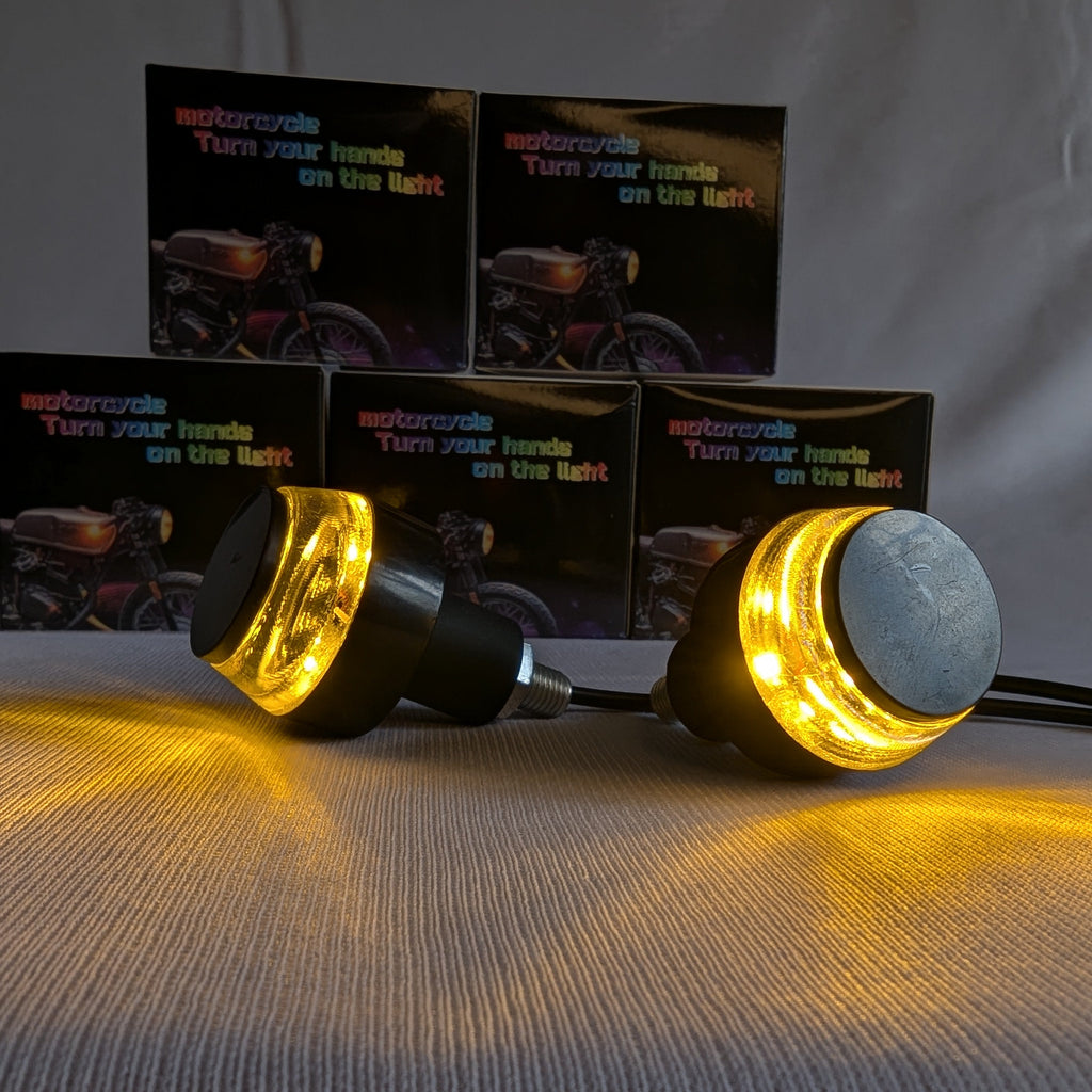 Motorcycle turn signal lights with warning labels on a gray background