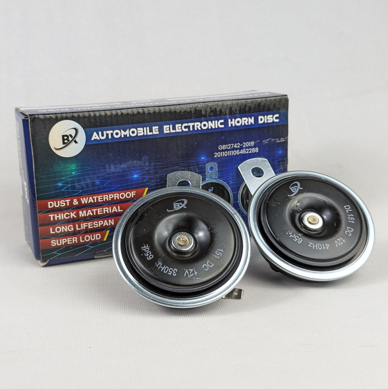 Automobile electronic horn discs with packaging on a light gray background