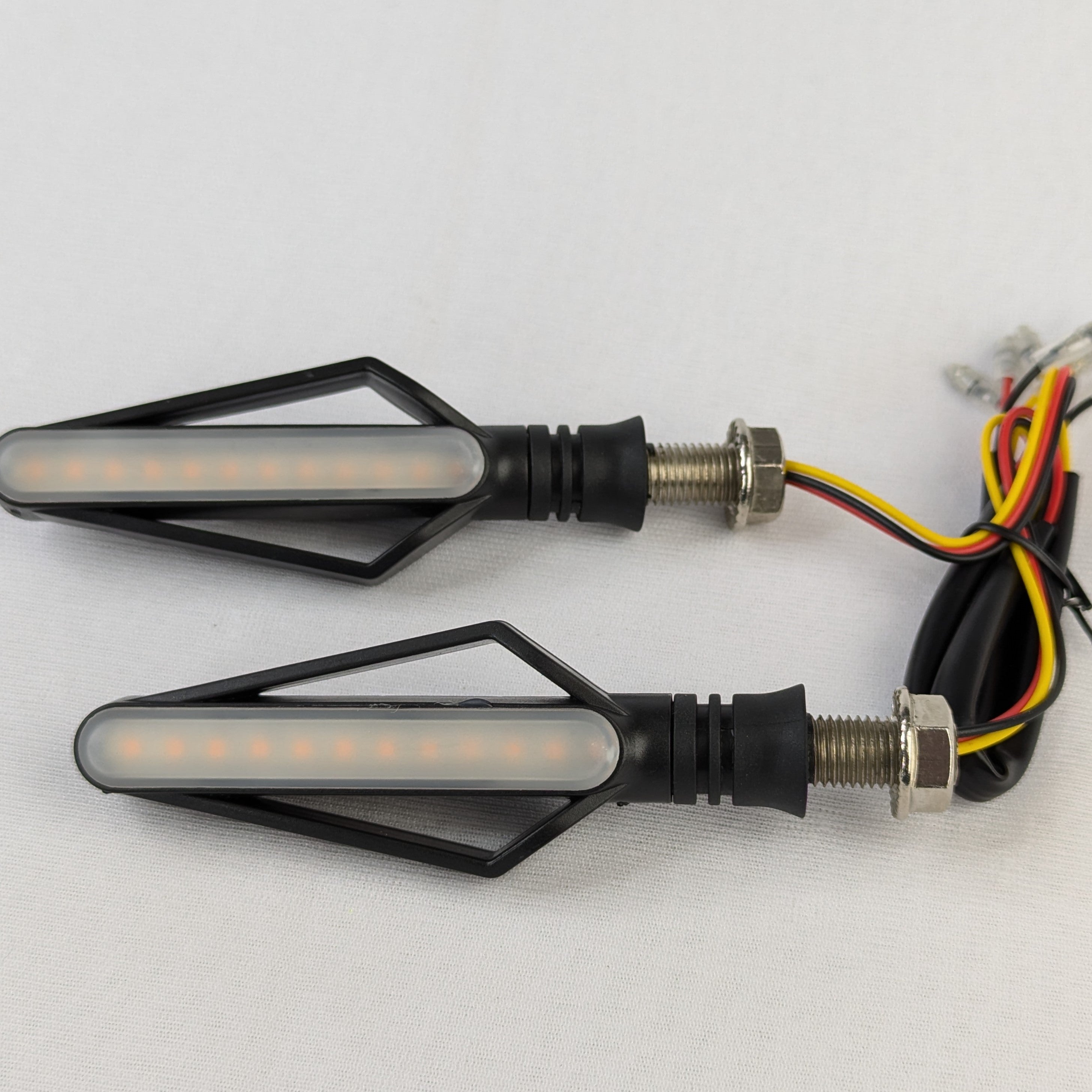 Two motorcycle turn signals with wiring on a white background