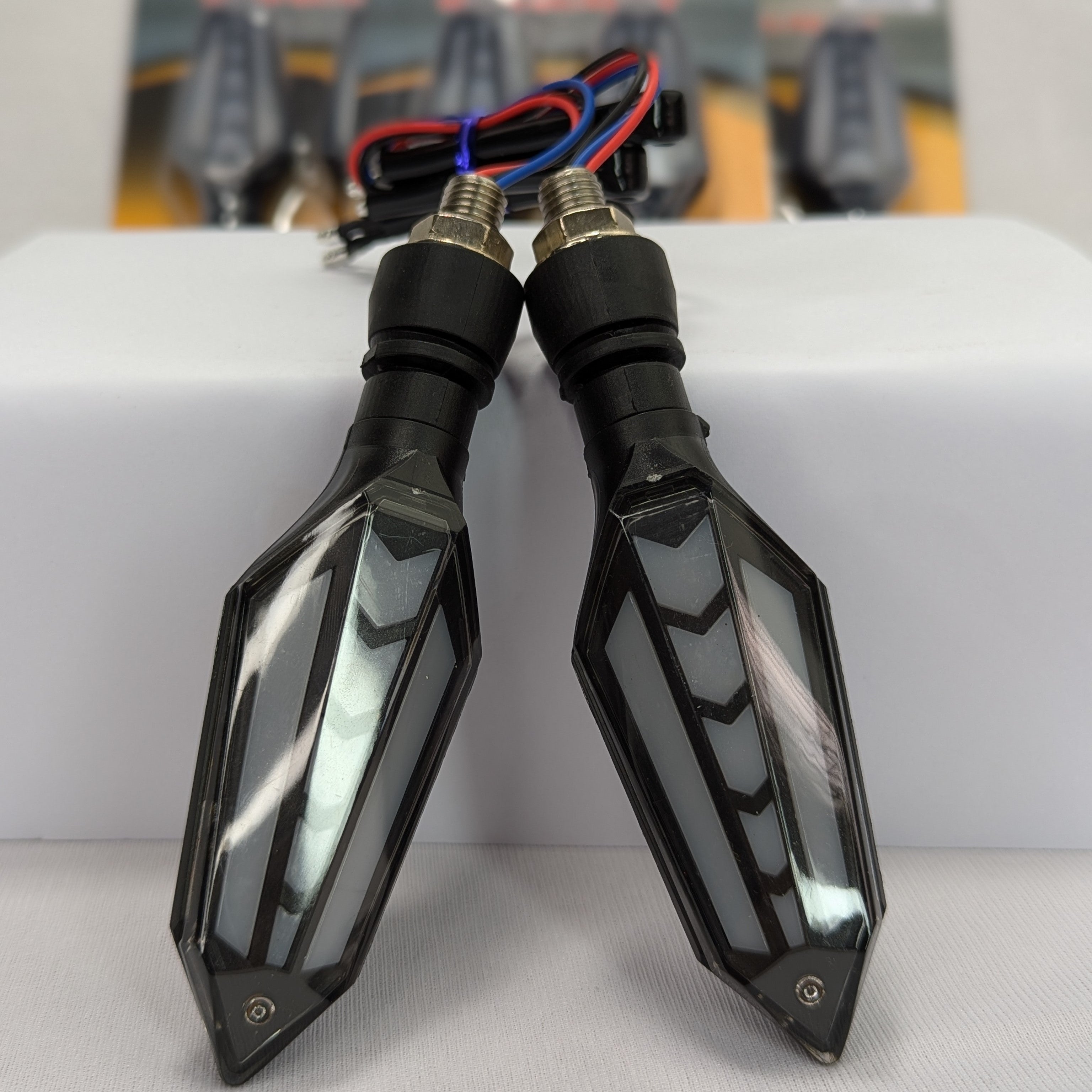 Pair of motorcycle turn signals with clear lenses on a white background