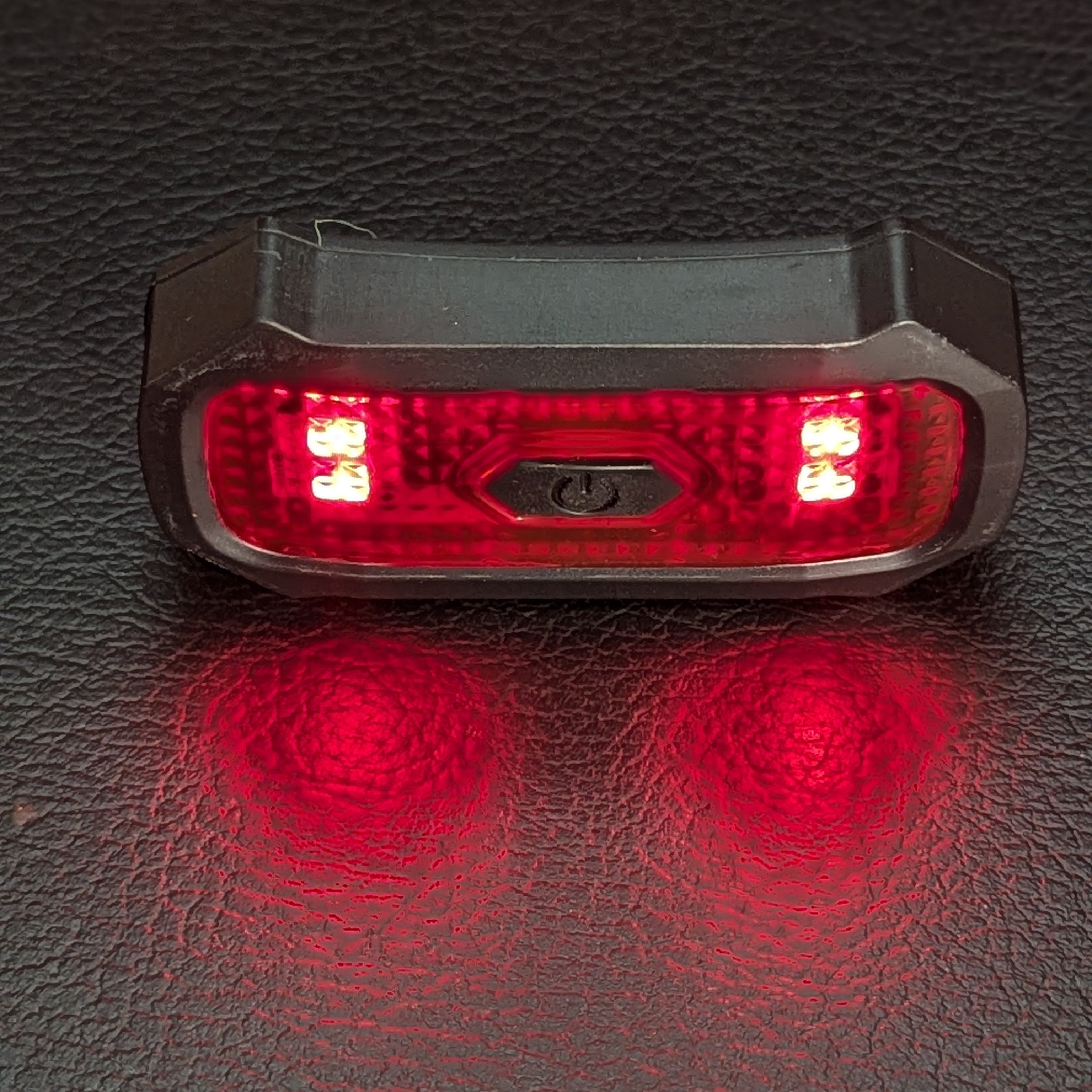 Red LED light on a textured black surface