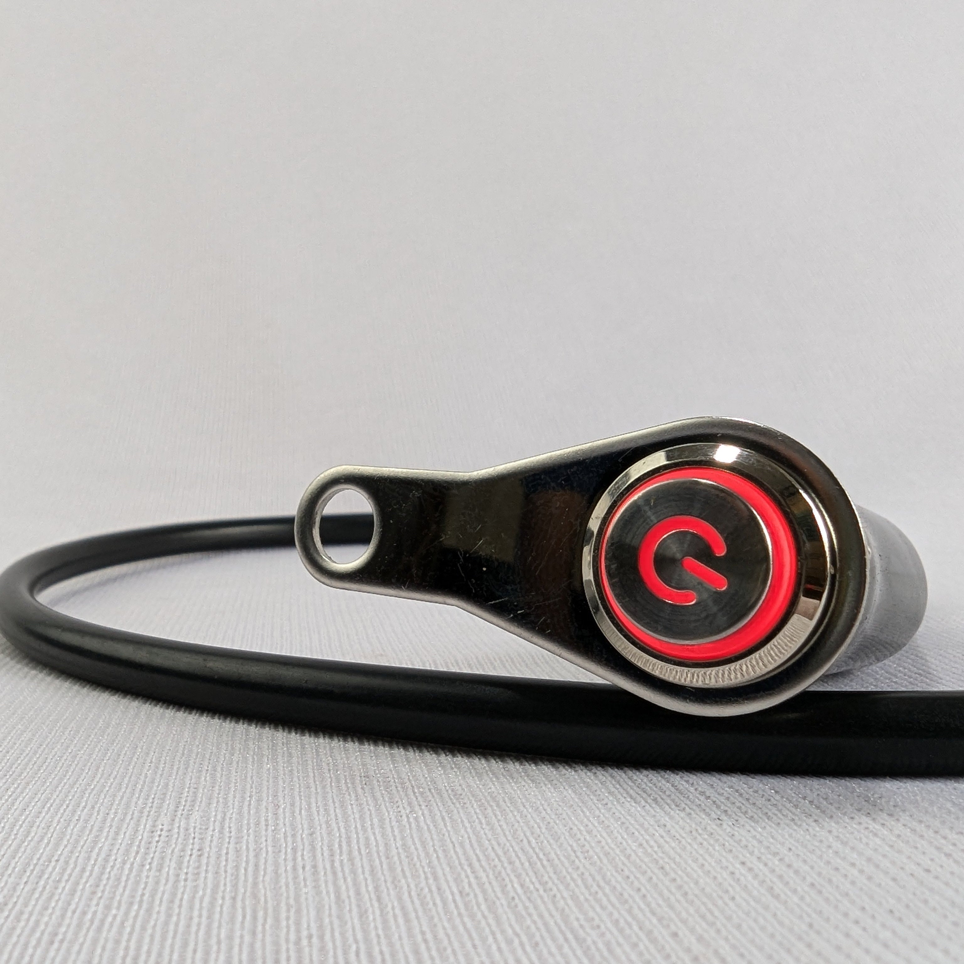 Black and red device with a circular component on a light gray background