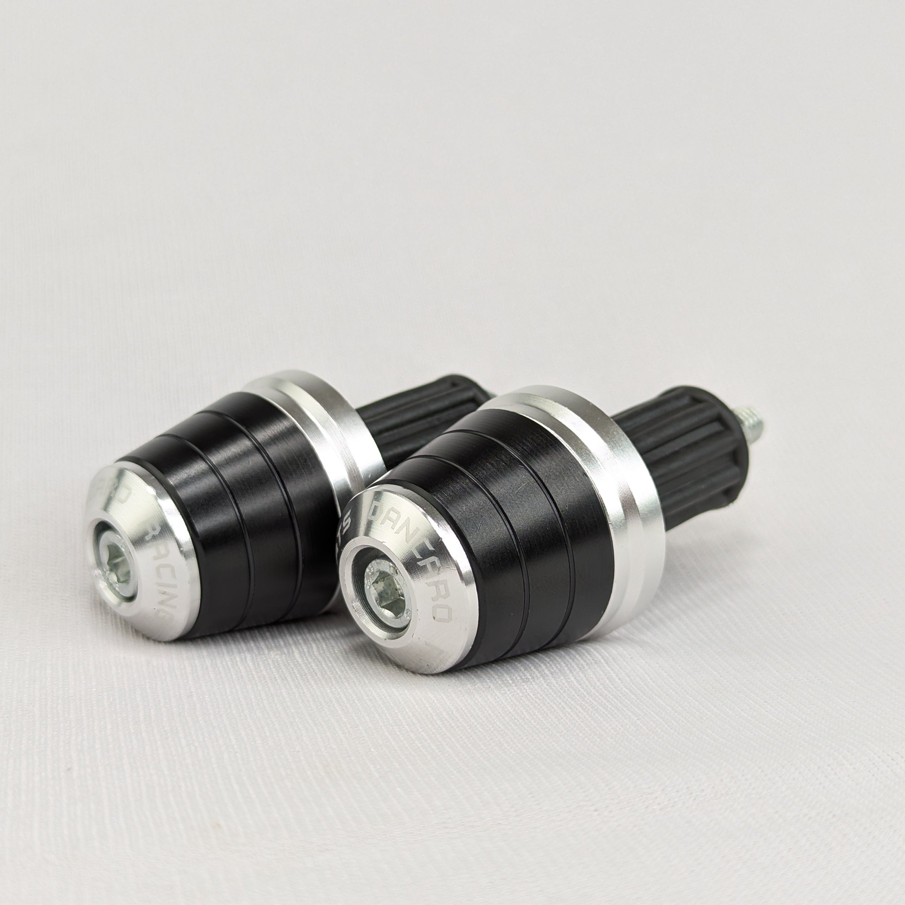 Two black and silver cylindrical objects on a light gray background