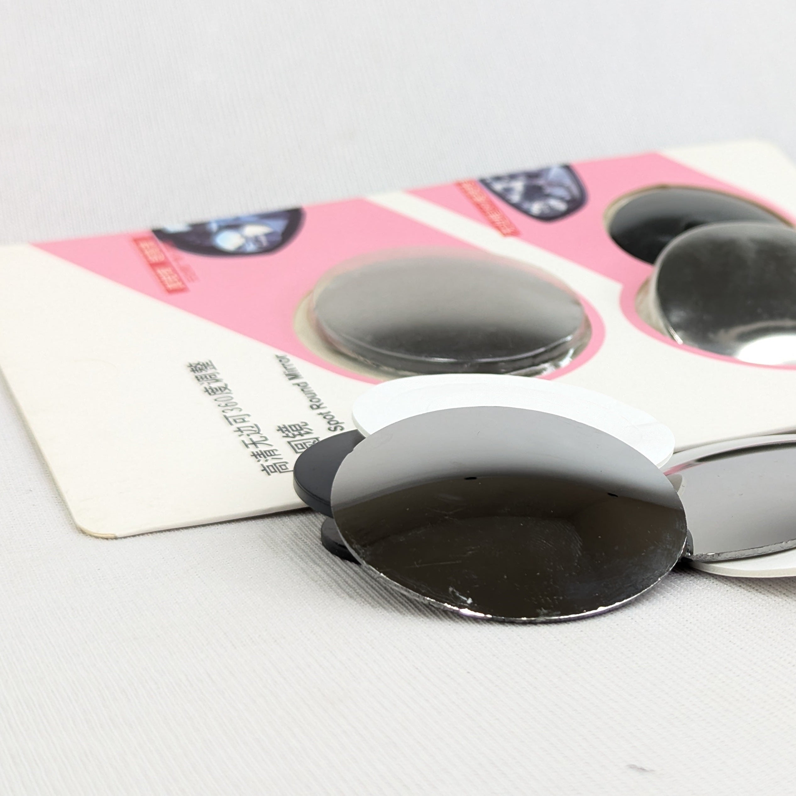 Black adhesive patches on a white card with pink border