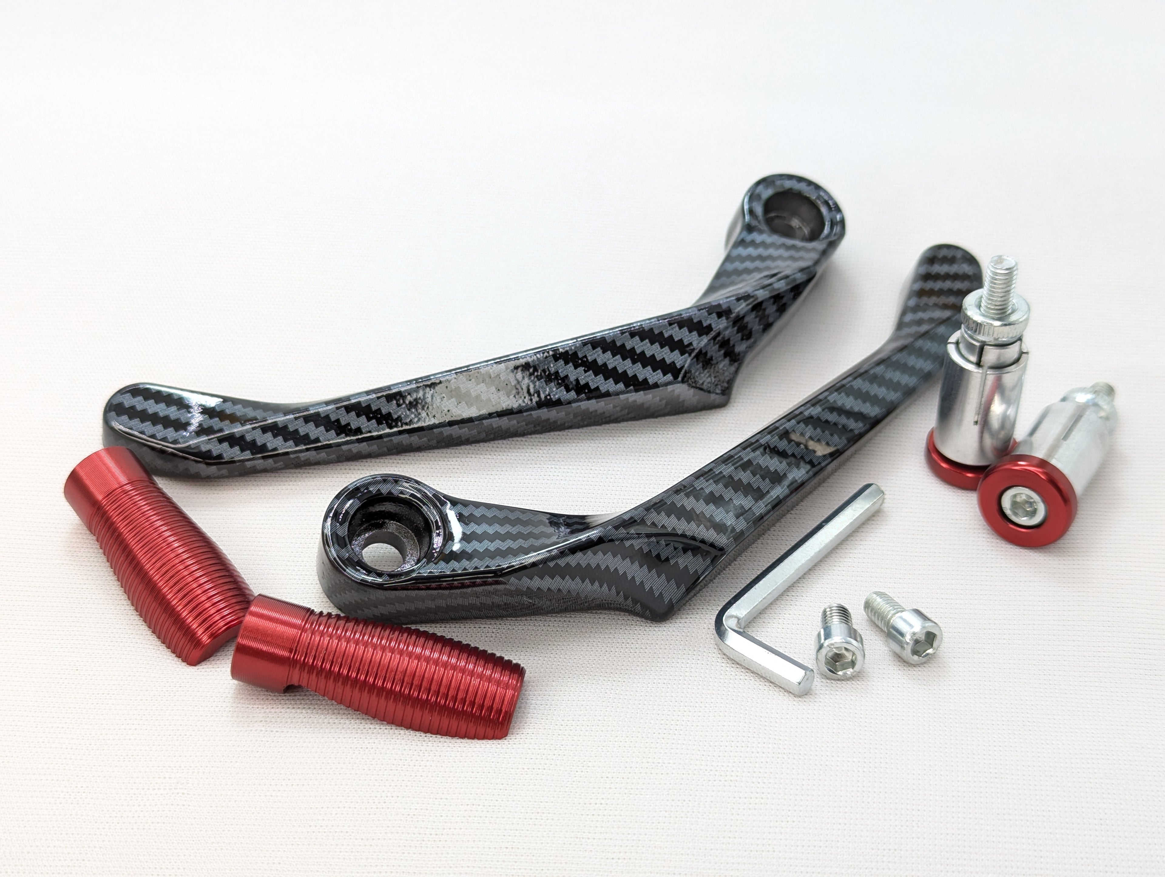 Carbon fiber components with red and silver fasteners on a white background
