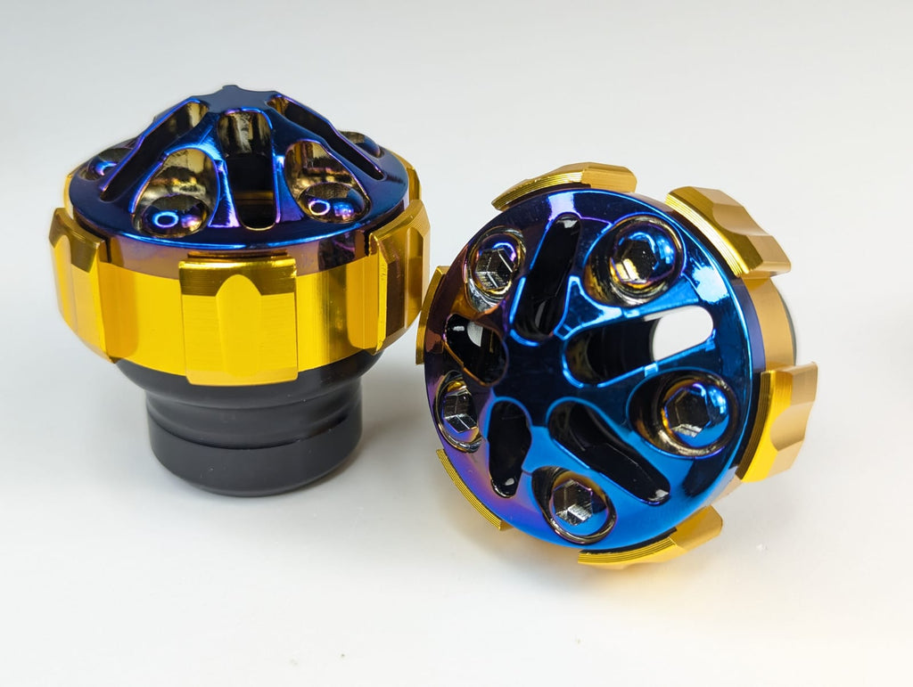 Two metallic metal parts with blue and gold finish on a white background